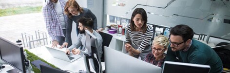 Image of six people collaborating on laptop and desktop computers