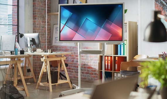 Modern office with large digital display on a cart.