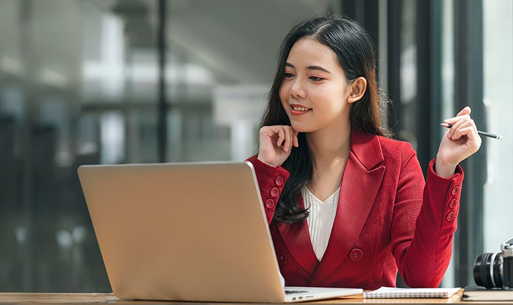 Young professional woman looking at a laptop.