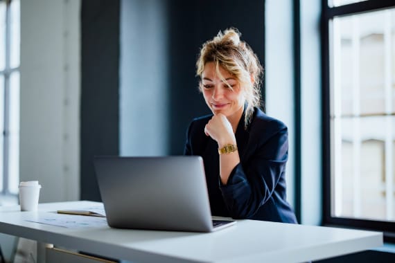 Happy business person working on a laptop.