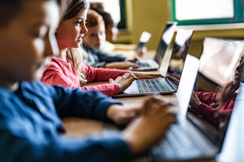 Young students are using laptops in the classroom.