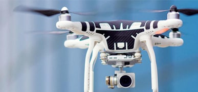 Closeup of a drone midflight carrying a camera