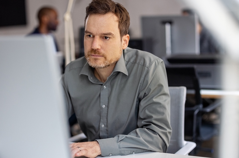 Tech specialist managing IT tasks at a computer station.