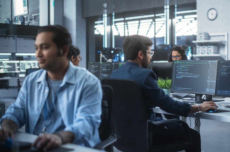 Technology professionals focused on tasks in office.