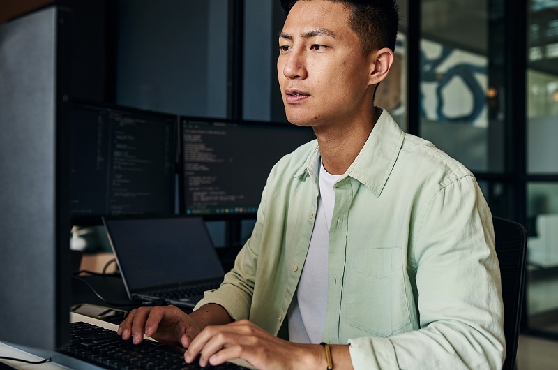Tech specialist concentrating on work at desktop.