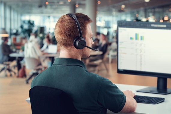 thumbnail image of a man wearing a headset working on a desktop computer