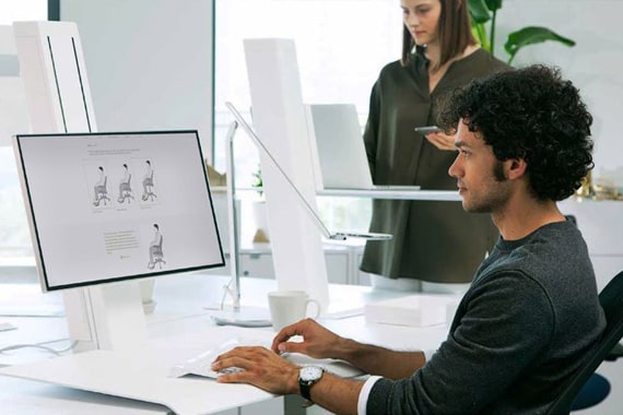 Man working on his computer in ergonomic workspace 