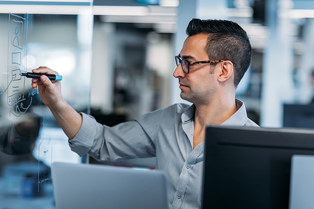 Government employee drawing on whiteboard to visualize modernization journey.