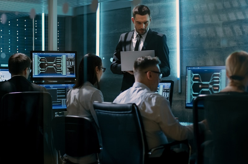 IT team in dark room reviewing network data.