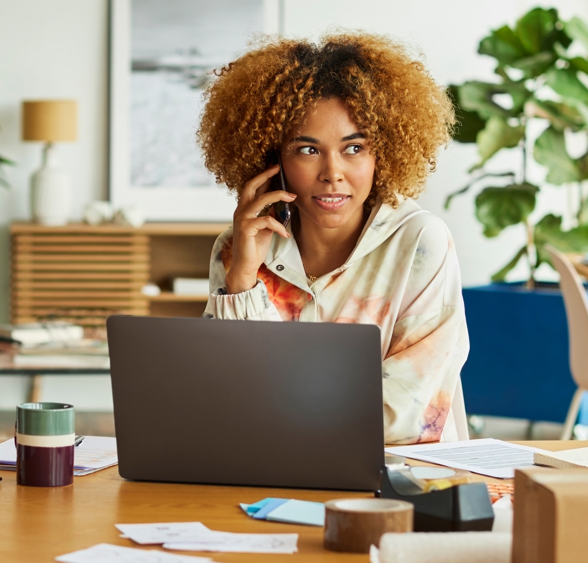 Woman working on her laptop and on the phone