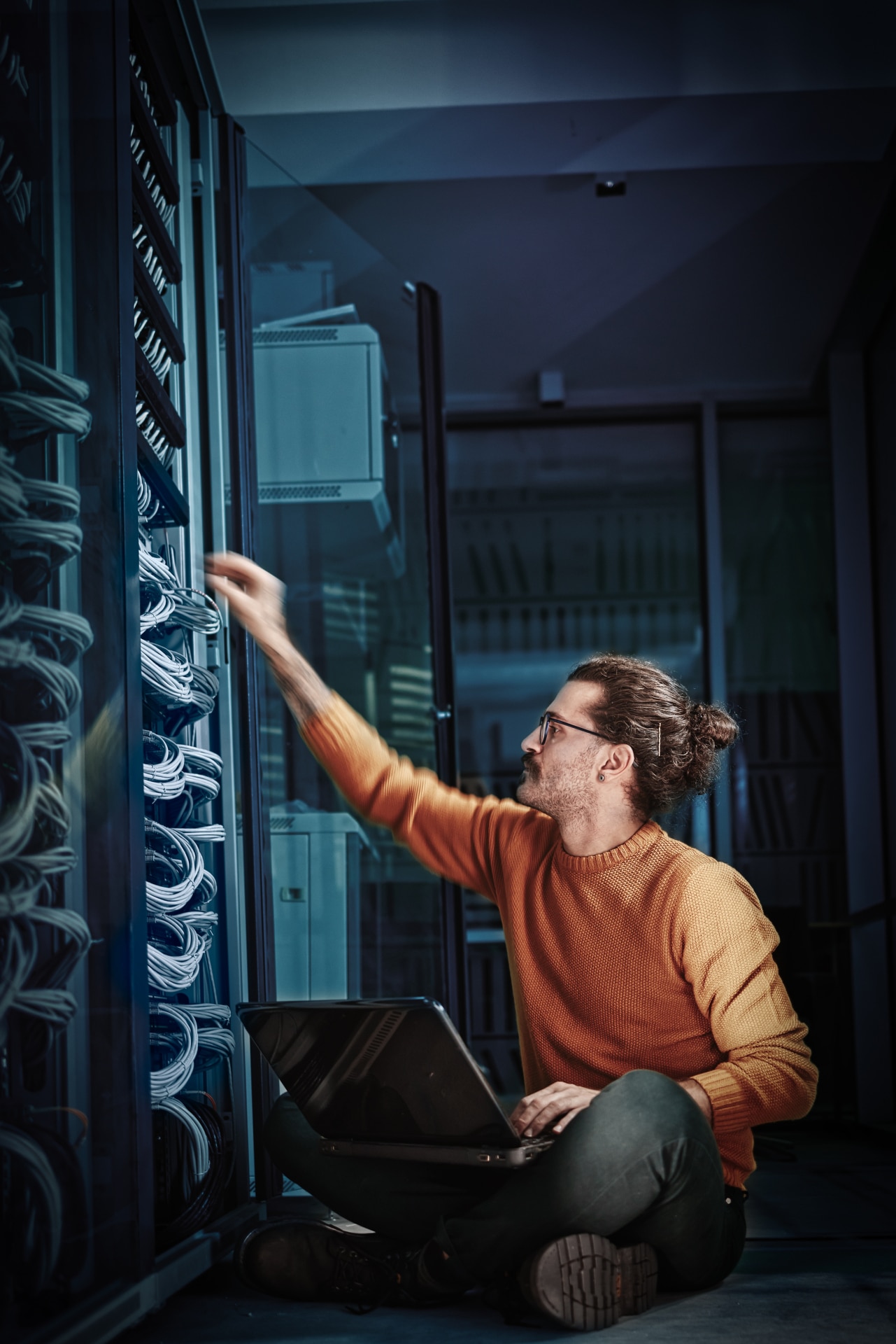 IT auditor inspecting server rack cabling during a security audit