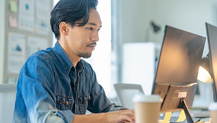 card image of a man working on a computer inside an office