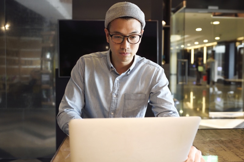 IT Expert working remotely on cloud infrastructure from a laptop.