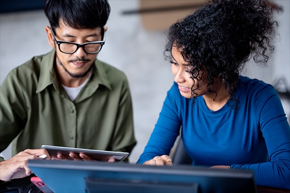 image of two IT specialists reviewing data on a tablet
