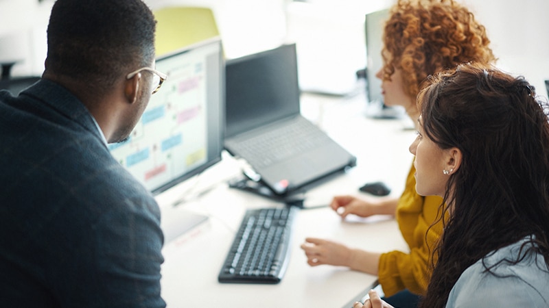 Office coworkers using Google Workspace in bright office