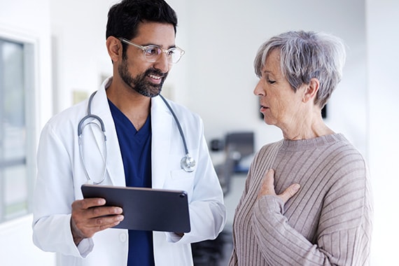 Doctor Discussing Health With Senior Patient in Hospital