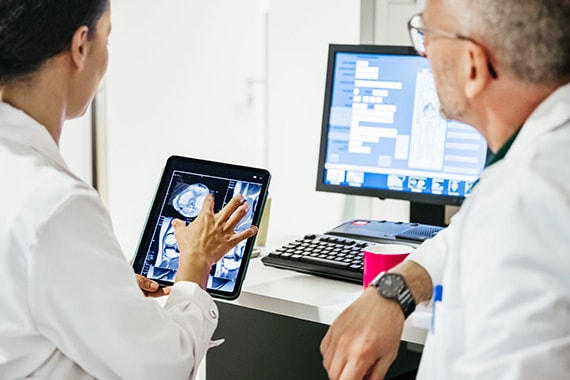 Doctors Reviewing Digital Scans on Tablet and Desktop Computer