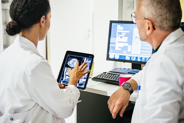 Doctors Reviewing Digital Scans on Tablet and Desktop Computer