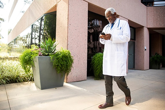 Doctor Walking Holding Smartphone