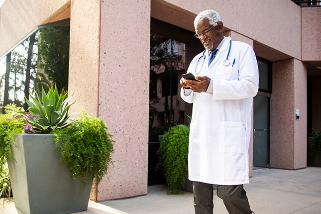 Doctor Walking Holding Smartphone