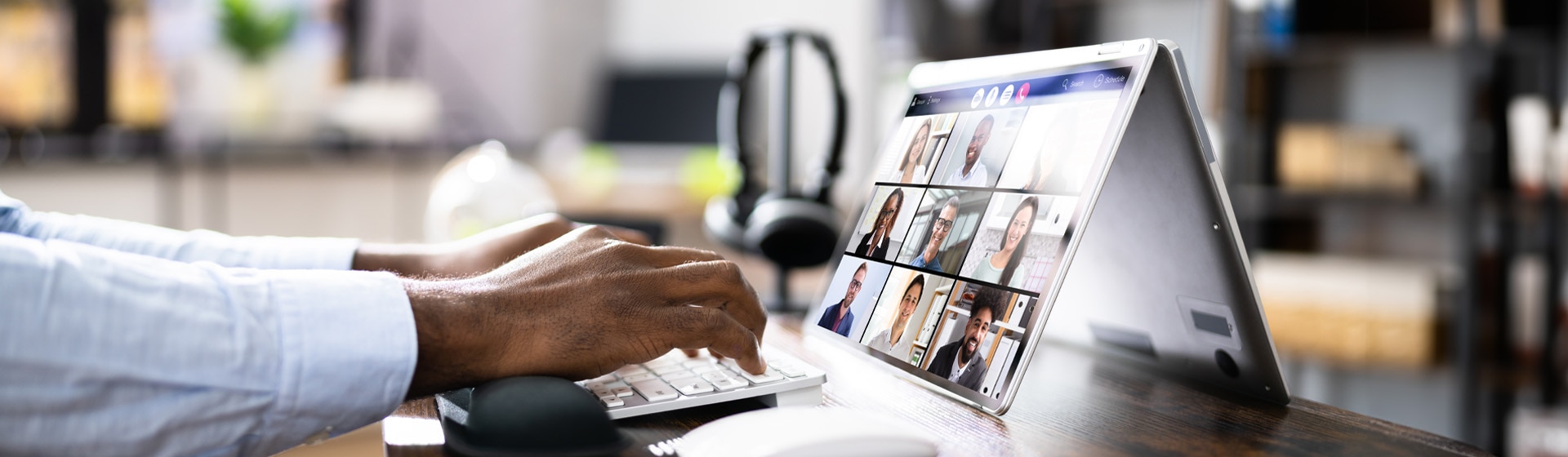 Person working on laptop while attending a virtual meeting.