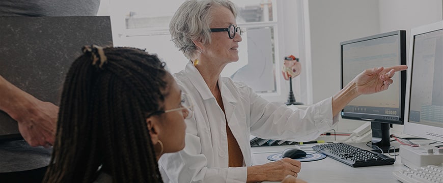 Doctors talking to MRI technicians about Magnetic Resonance Images MRI while pointing at computer screens.