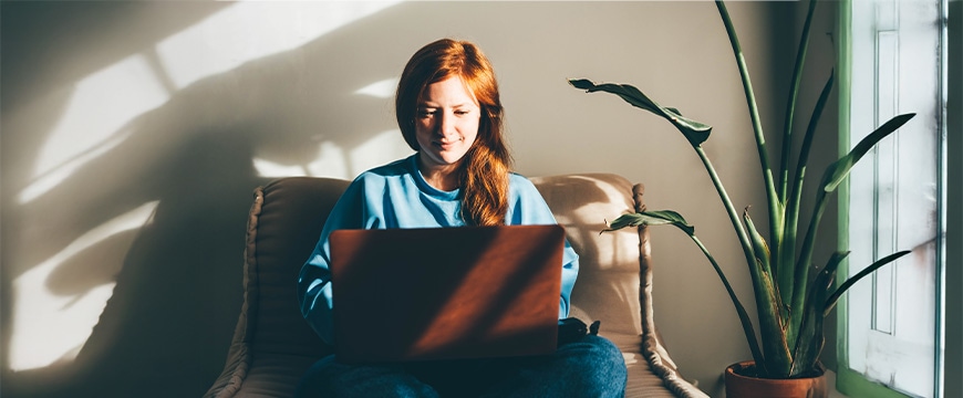 Young woman with laptop working in living room