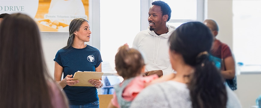 Diverse Couple consults each other during volunteer event