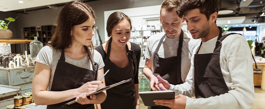 Male and female colleagues discussing over digital tablet at store