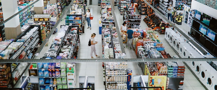 Business manager taking inventory at a clothing store using a tablet and her laptop