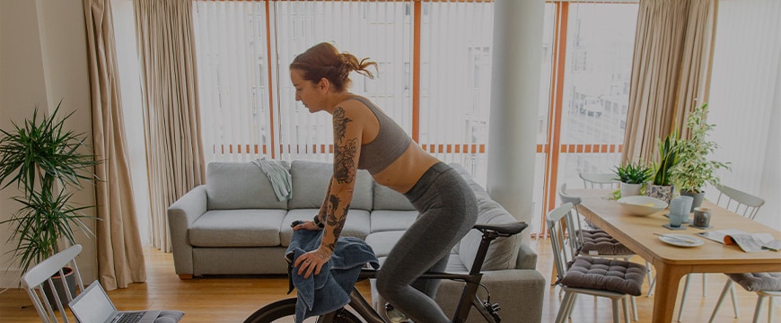 Woman working out on her indoors cycling turbo trainer
