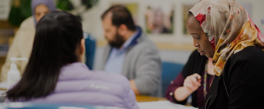 Diverse group discussing work at a community center meeting table