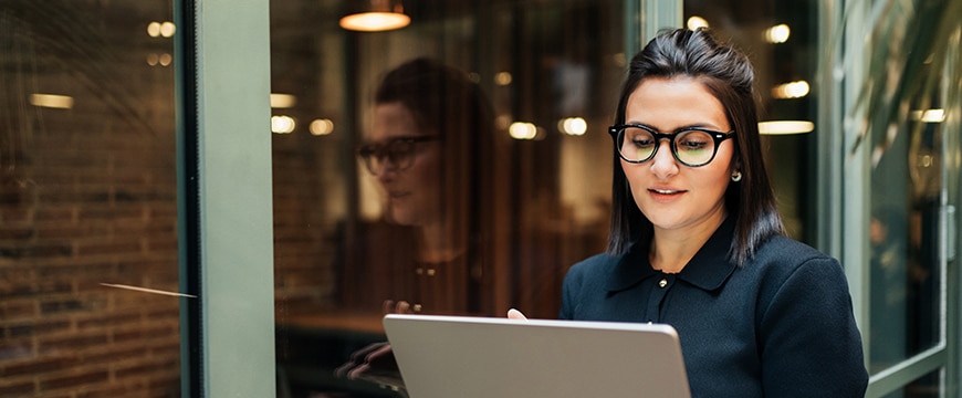 Woman in corporate setting with laptop.