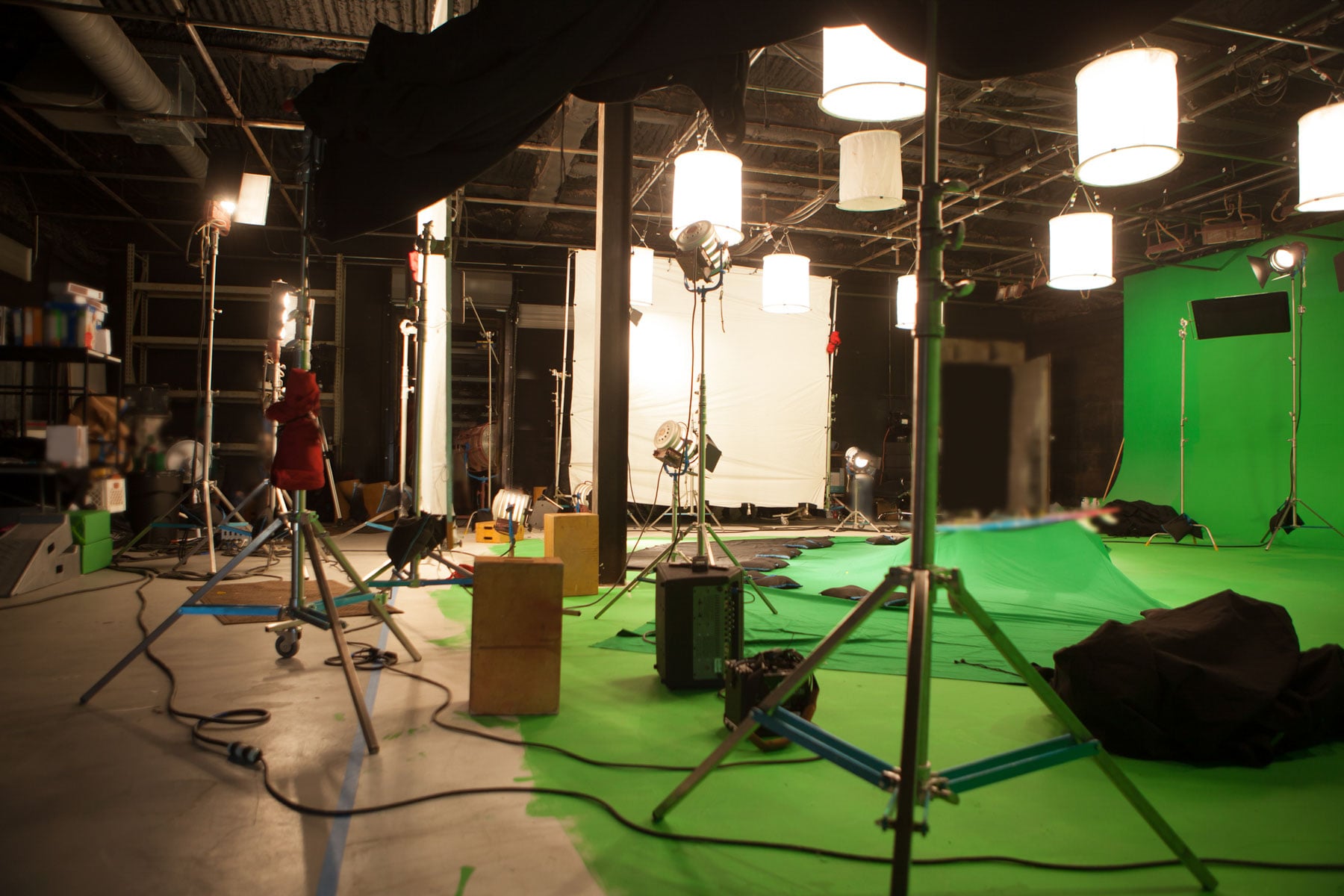 Image of an empty movie studio with a green screen and all equipment.