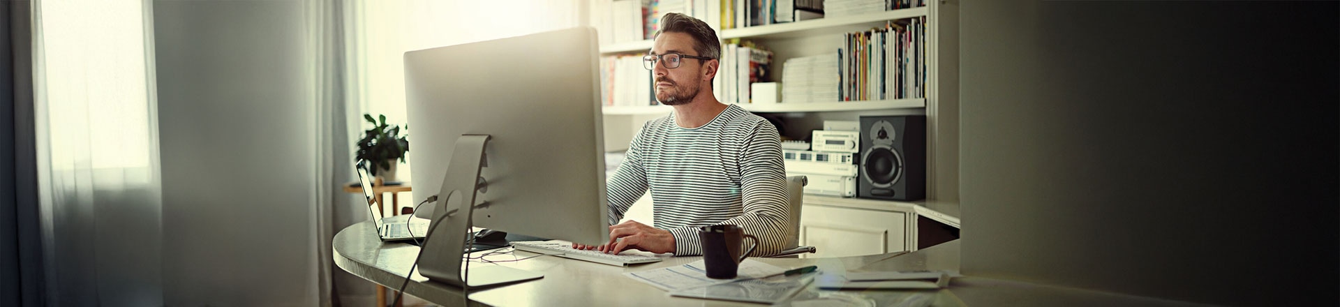 Cropped shot of a man sitting behind his computer in his home office image