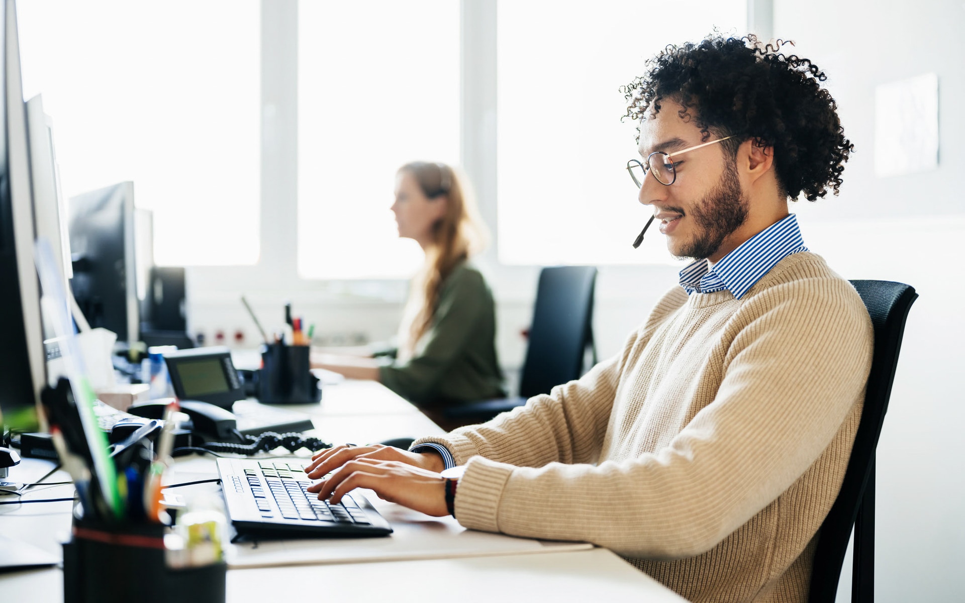 A customer service representative sitting on a computer