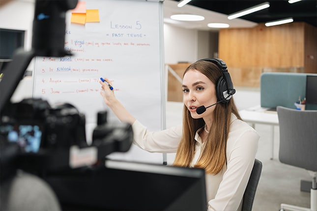 Teacher wearing headset in HyFlex classroom and instructing via online broadcast.