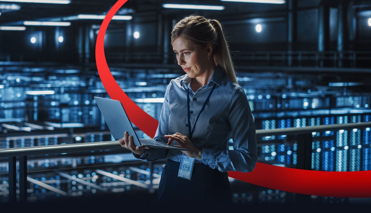 IT professional using a laptop in a modern data center, representing infrastructure modernization for AI, security, and scalable business growth.