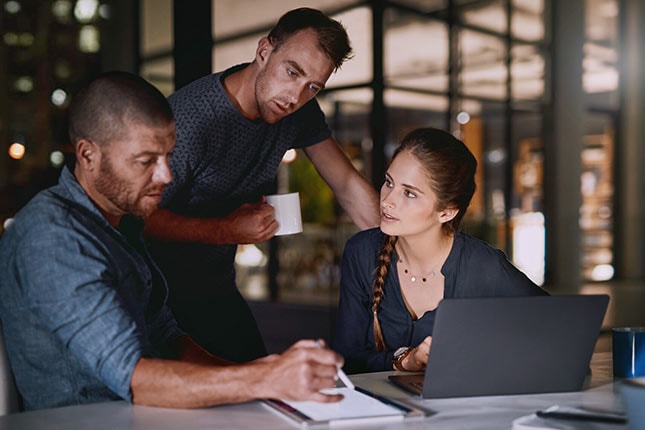 Shot of employees working late in the office