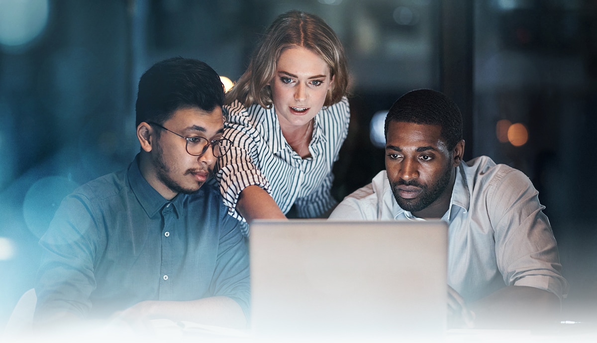 hero image of 3 IT specialists working on a laptop computer.