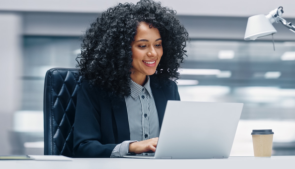 Person using laptop in bright office.
