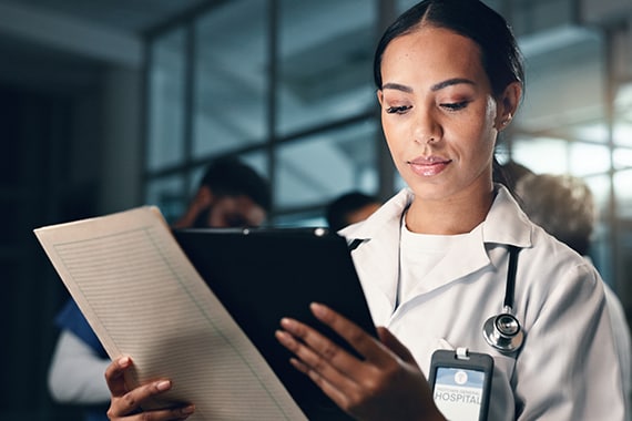 image of a female doctor reviewing information holding a tablet