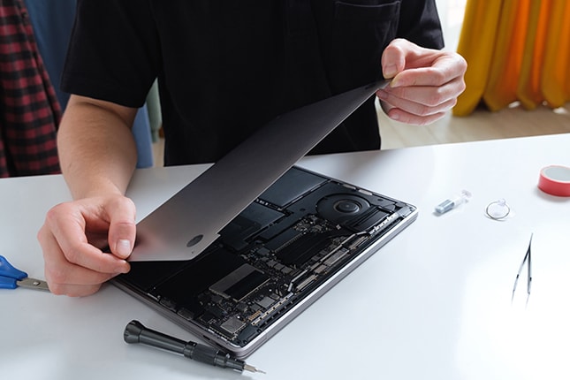 IT support repairing broken laptop.