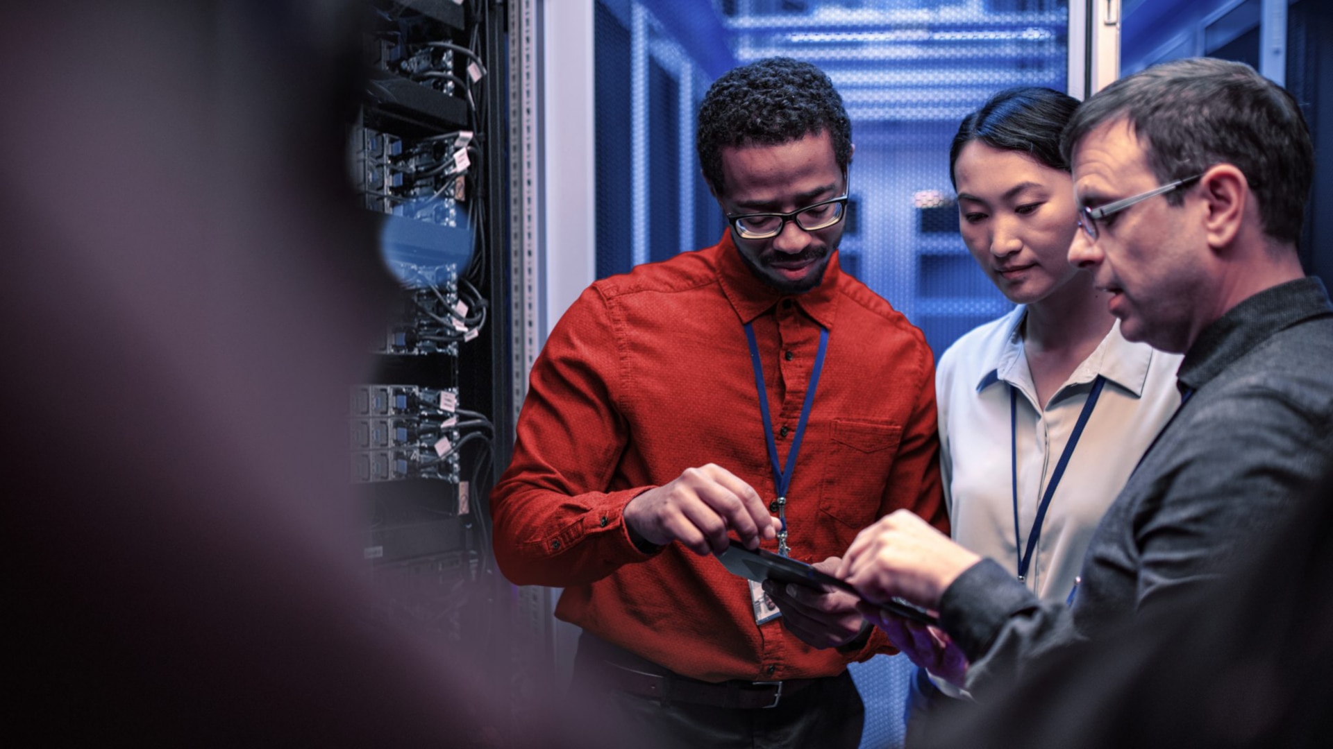 Two people standing next a sever rack discussing about something.