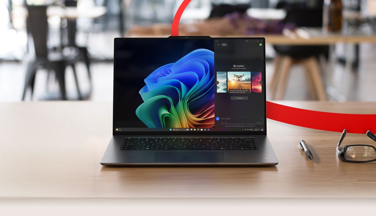 Lenovo laptop on a desk with Windows 11 screen, featuring CDW’s red orbital design element in the background.