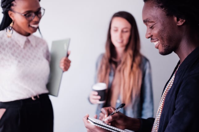 A male conversing with two female employees.