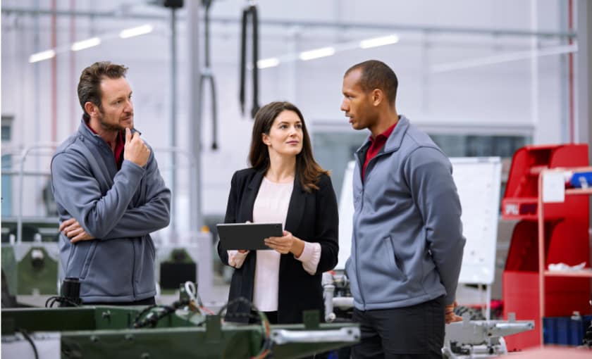 A female on a tablet discussing with two men.