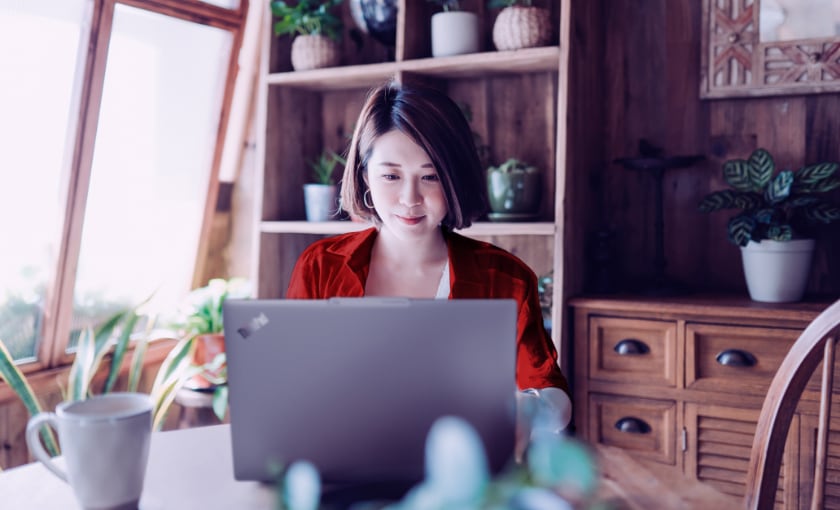 A woman working on a laptop in her home office.