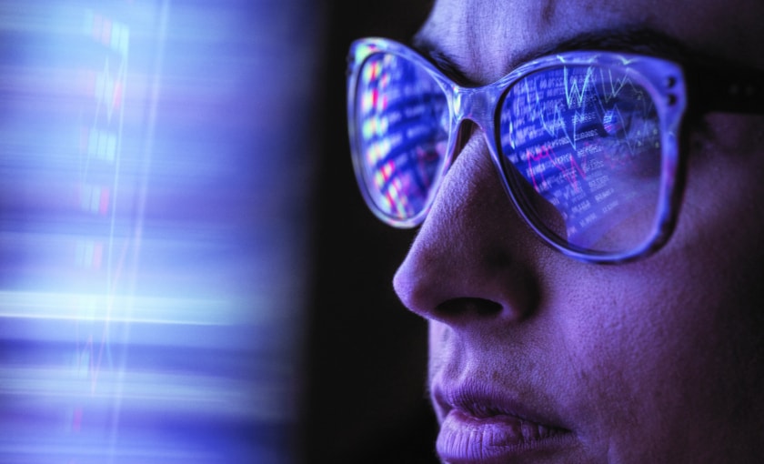 A woman with glasses looking at data.