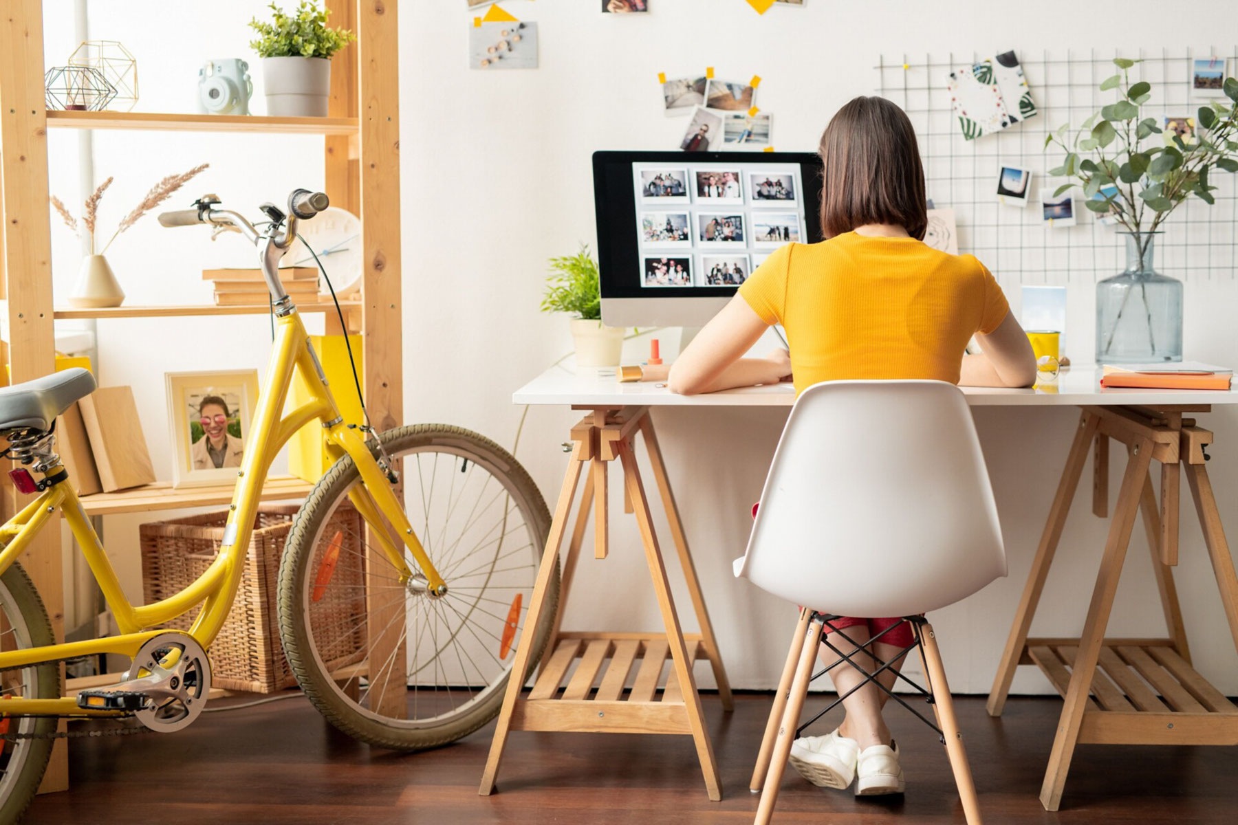 Girl sitting in front of Imac while sitting on a study table.